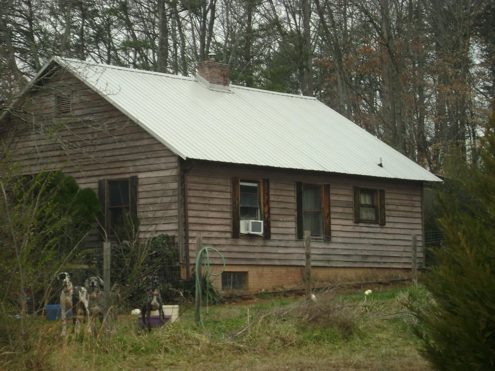 White metal roof on an old wood sided farmhouse, from a Metal Roof Installation job in Laceyville